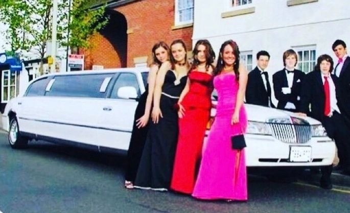 Group of guests in formal attire with B&B Limousine vehicles